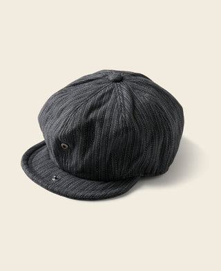 Black and gray yarn-dyed newsboy cap with curved brim and buttoned crown.
