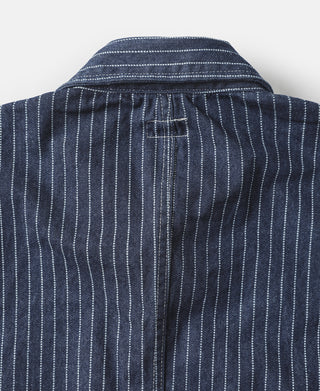 Indigo pinstripe work coat back with curved yoke seam and stitched vertical paneling