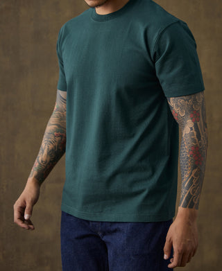 Dark green cotton crew-neck t-shirt on model, side view