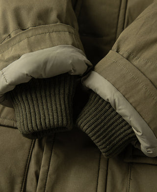 Olive parka cuff close-up: ribbed knit inner sleeve with wind flap