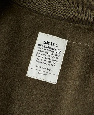 Olive jacket interior label marked SMALL with care and dated markings.