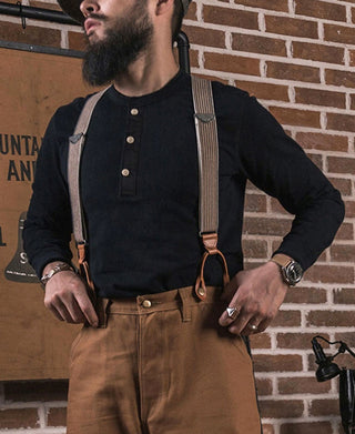 Black long-sleeve henley shirt worn with visible button placket and ribbed cuffs.
