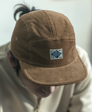 Khaki corduroy 5-panel cap close-up with front logo patch