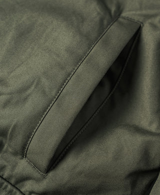 Olive jacket fabric panel with diagonal seam and visible stitching