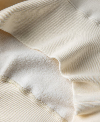 White raglan sweatshirt cuff and hem with worn textured fabric area