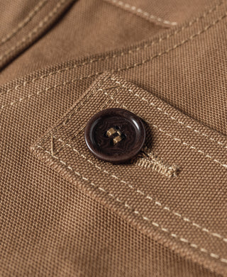 Khaki canvas hunting vest button detail with stitched pocket edge