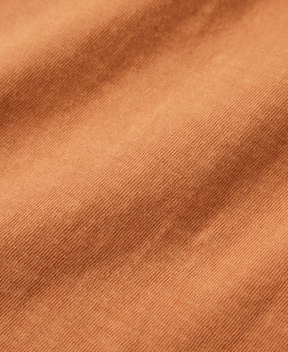 Orange slub cotton fabric close-up with visible textured weave.