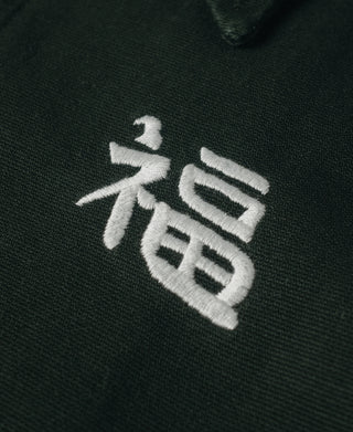 Dark green jacket with white embroidered character emblem on chest