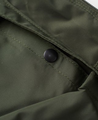 Olive nylon bag fabric detail with snap button and seam stitching