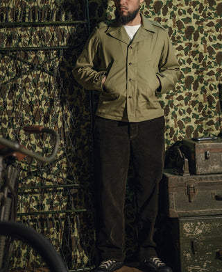 Olive green field jacket on man, button front and cuffed sleeves