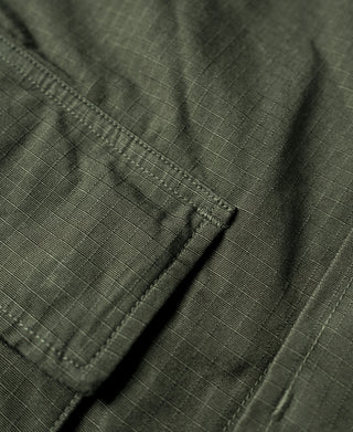 Olive jacket seam detail with stitched panel and pocket edge
