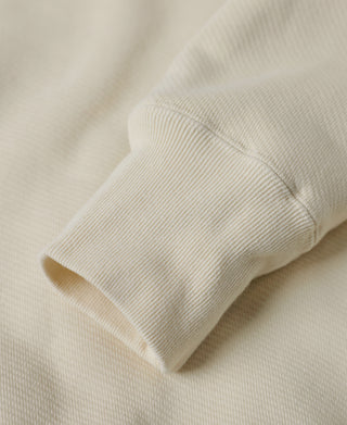 Apricot fleece sweatshirt ribbed sleeve cuff and stitched hem close-up