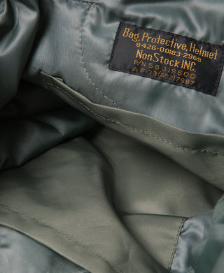 Inside view of olive tote bag showing brown brand label and stitched lining panel