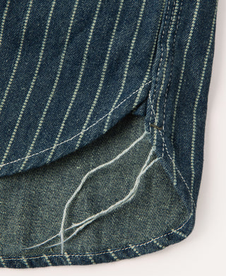 Indigo striped work shirt hem close-up with stitched side panel and tacks