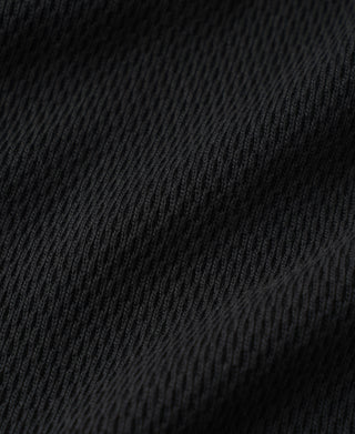 Black thermal waffle knit fabric close-up, fine textured knit