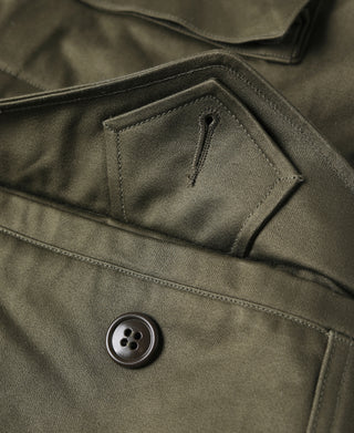 Olive field jacket side pocket with flap and dark four-hole button