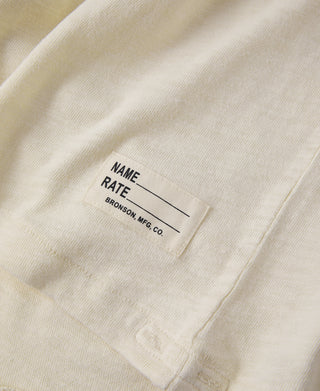 Light apricot slub cotton T-shirt fabric tag at hem with name and company label