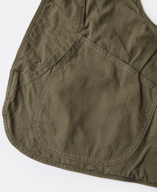 Dark olive canvas vest with rounded patch pocket and stitched hem