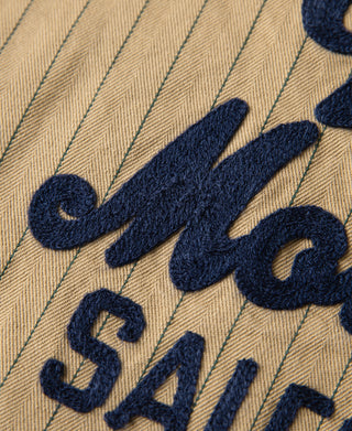 Navy embroidered lettering on khaki striped chore coat back