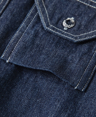 Dark blue denim workshirt pocket flap corner with small logo button