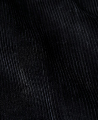 Black corduroy fabric close-up showing fine vertical wale texture
