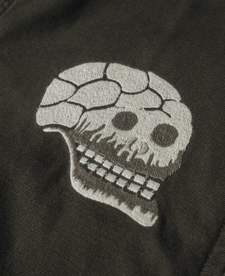 Olive jacket close-up of white skull embroidery with stitched teeth