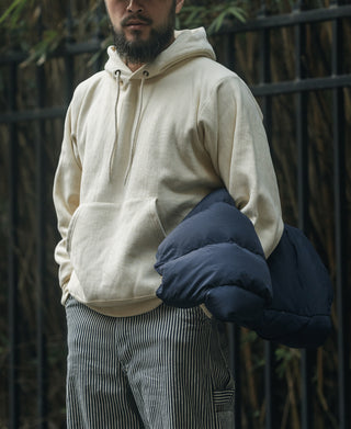 Apricot reverse-weave pullover hoodie with kangaroo pocket and drawstring hood.