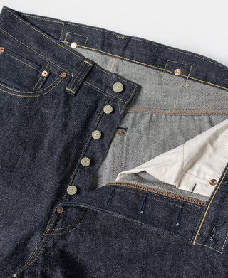 Indigo denim jeans interior view showing waistband, pockets, and copper-tone buttons