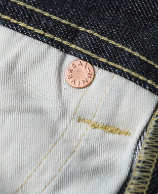 Indigo selvedge denim jeans with tan leather patch and yellow bartack stitch