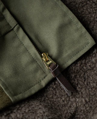 Olive flight jacket front with brass zipper and pull at the collar seam