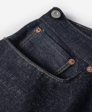 Indigo denim jeans front pocket with brown metal rivets and coin pocket detail