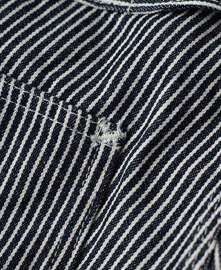 Striped carpenter pants front pocket flap with visible bar-tack reinforcement