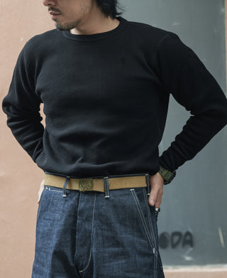 Black waffle-knit long-sleeve crewneck cotton top worn by a model