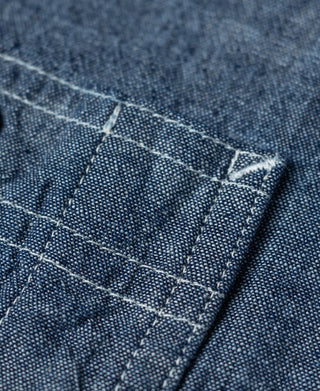 Blue chambray work shirt pocket panel with grid stitching and reinforced edges