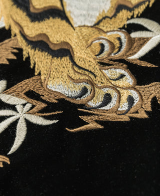 Embroidered tiger face motif on black reversible jacket with gold and white thread.