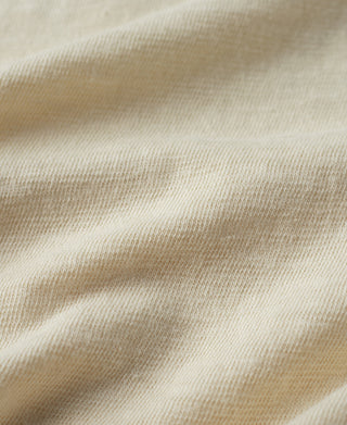Cream T-shirt fabric texture close-up with subtle knit grain