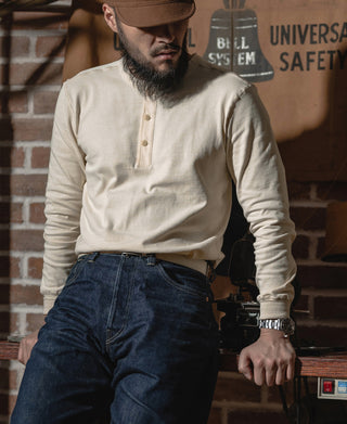 Apricot long-sleeve henley shirt with 3-button placket and ribbed collar, worn