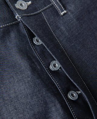 Indigo dungaree pants close-up of snap-button placket and side seam