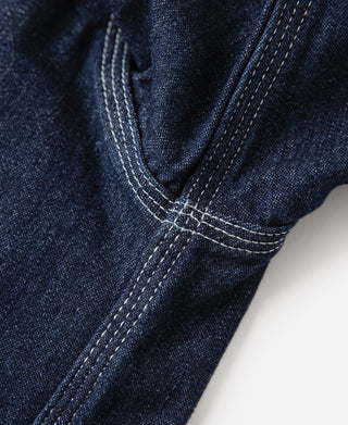 Denim workshirt cuff with contrast-stitched seams and button placket, dark blue wash