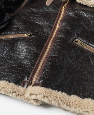 Dark brown leather flight jacket with side zip pocket and tan shearling trim at hem
