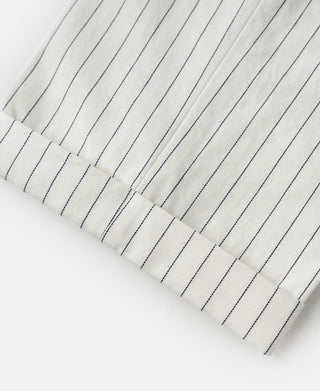 White pinstripe pants hem close-up with stitched cuff and vertical stripes