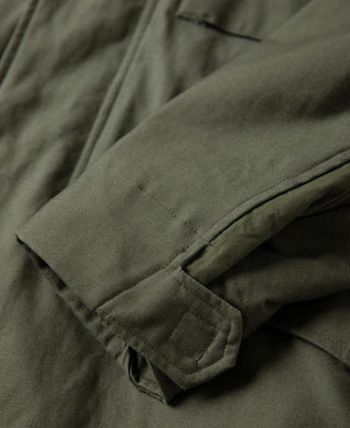 Olive field jacket sleeve cuff with fold-over hem and button tab