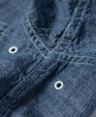Blue chambray work shirt button placket with ring-style buttons and yoke seam