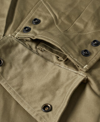 Khaki green jacket pocket flap with zipper pull and snap button detail