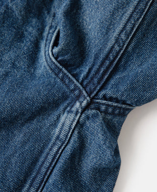 Indigo stonewashed zip-up denim work jacket, close-up of front seam and stitching