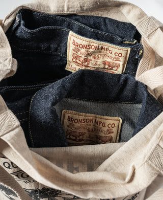 Natural linen tote bag interior with dark lining pockets and BRONSON MEG CO labels.