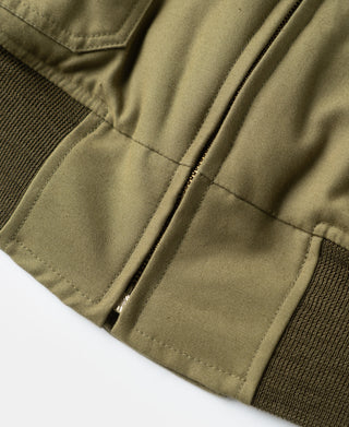 Khaki flight jacket sleeve hem with stitched panel and dark knit cuff