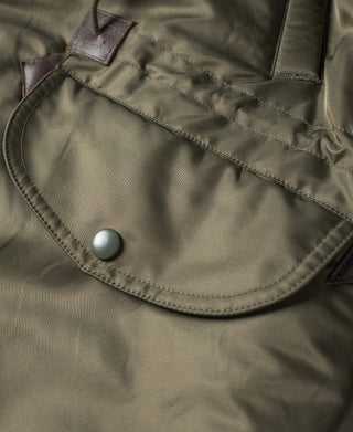 Olive N-3 parka pocket flap with two round buttons and stitched hem.