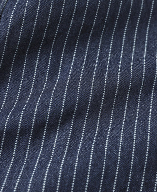 Indigo pinstripe work coat fabric close-up with white vertical stripes