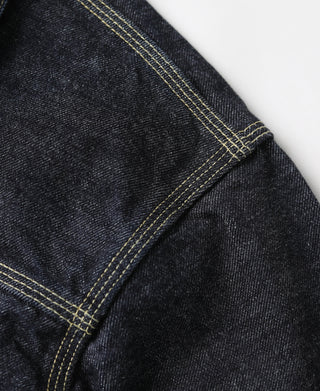 Indigo denim jacket side seam with yellow topstitching and angled panel
